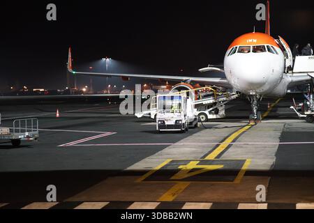 Passenger aircraft on the airport apron at night with ground vehicles and crew preparing the flight.Nantes,France Stock Photo