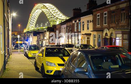 Mersey Road, West Bank, Widnes, with the Silver Jubilee Bridge towering over the houses. The bridge was opened in 1961, pictured here in December 2025 Stock Photo