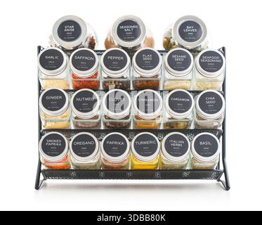 Assorted spices in glass jars with metal lids on a black metal shelf  isolated on white background, clipping path included. Stock Photo