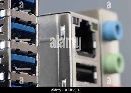 Close-up of a metal back panel featuring stacked USB ports, RJ 45, and color audio jacks Stock Photo