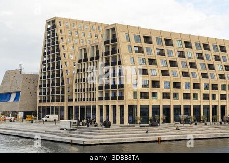 View of modern architectural marvels rise from the waterfront, their geometric facades casting shadows on the tranquil harbor, Indre By, Copenhagen, D Stock Photo