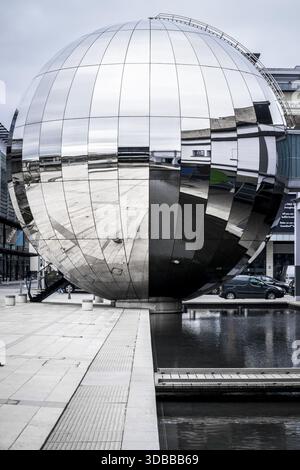 View of the iconic silver mirrored globe sculpture reflecting the surrounding architecture in a serene water feature, a modern marvel, Bristol, Englan Stock Photo