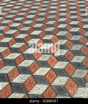 View of a mesmerizing geometric dance of red, black, and gray blocks creates a captivating 3D illusion underfoot, Kuala Lumpur, Federal Territory of K Stock Photo