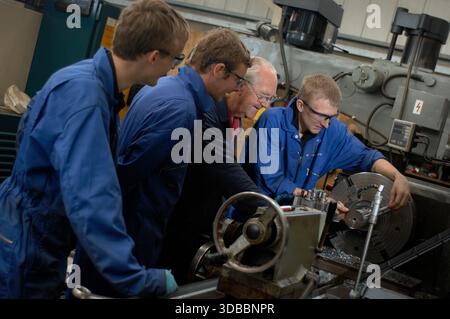 Male & female engineering apprentices learning and receiving tuition from time-served and experienced engineers. Stock Photo