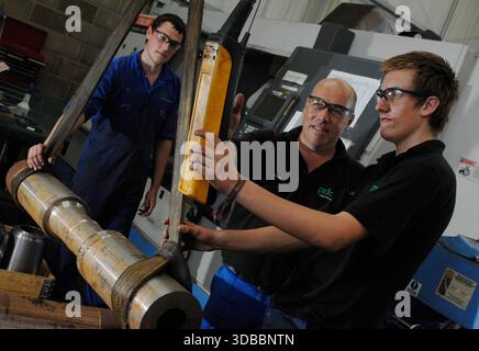 Male & female engineering apprentices learning and receiving tuition from time-served and experienced engineers. Stock Photo