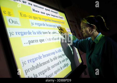 School pupils in a class using an interactive white board. Stock Photo