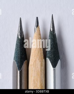 Close-up of the sharp tips of three graphite pencils placed close to each other, white background, macro Stock Photo