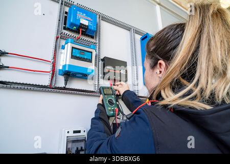 Technician using multimeter for testing electrical components on a solar power system Stock Photo