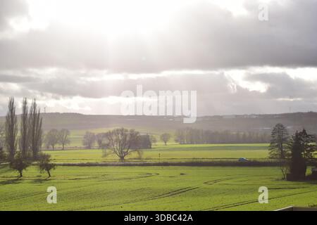 storm clouds on winter green farmland Stock Photo