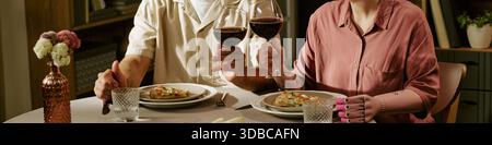 Header of Young Couple Toasting Wine Glasses While Enjoying Romantic Dinner Stock Photo