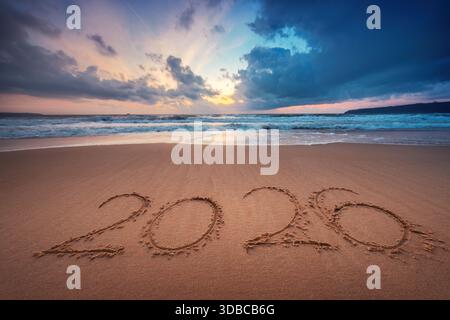 Happy New Year 2026 concept, lettering on the beach. Written text on the sea beach at sunrise. Stock Photo