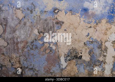 Abstract weathered and cracked paint peeling on old blue and beige wall texture Stock Photo
