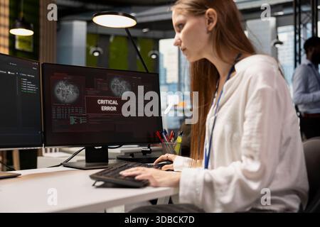 Troubled software developer reviewing error logs at work, trying to to resolve critical glitches. Tense young inexperienced worker debugging code in office, looking for solutions to fix errors Stock Photo