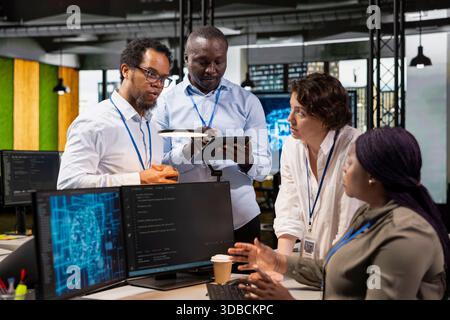 Admins doing brainstorming in office, automating repetitive tasks using AI on PC. Startup coworkers discuss during meeting about artificial intelligence tech usage to speed up feature implementation Stock Photo