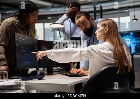 Teamworking programmers doing brainstorming, adjusting deep learning algorithms parameters to automate tasks. Team of IT experts working together in technology company, doing code optimization with AI Stock Photo