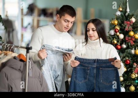 couple chooses jeans instead in a clothing store Stock Photo