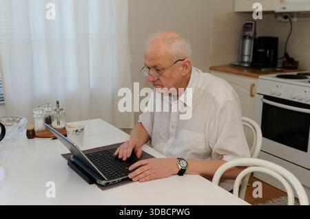 Elderly man working with a laptop Stock Photo