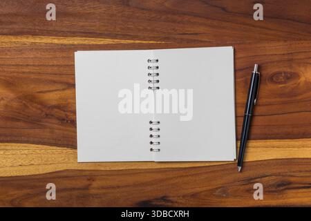 Blank notebook and pen on wooden table. Stock Photo