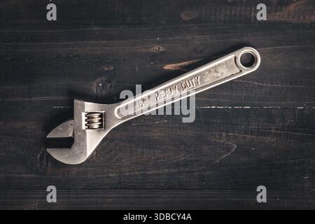 Adjustable wrench on wooden table. Heavy duty tool Stock Photo