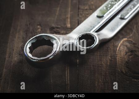 Close-up of wrenches on wooden table in dark moody theme Stock Photo