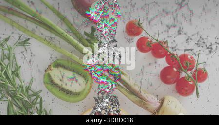 Showing produce cluster with halved kiwi, scallions, tomato vine and metallic glitch on white table Stock Photo