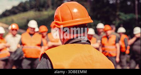 A group of people wearing construction helmets at a construction site Stock Photo