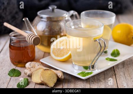 Ginger tea with honey and lemon in a cup on wooden table Stock Photo
