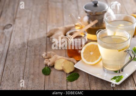 Ginger tea with honey and lemon in a cup on wooden table Stock Photo