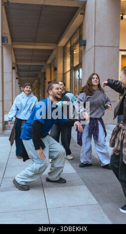 Young hip hop dancers practicing together near modern office buildings. Stock Photo