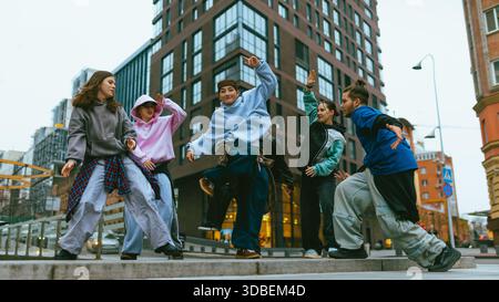 Hip hop dancers practicing freestyle routine on modern city square. Stock Photo