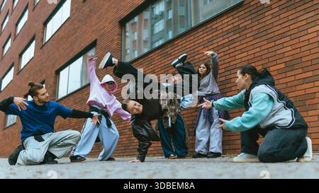 Street dance group rehearsing choreography in city environment Stock Photo