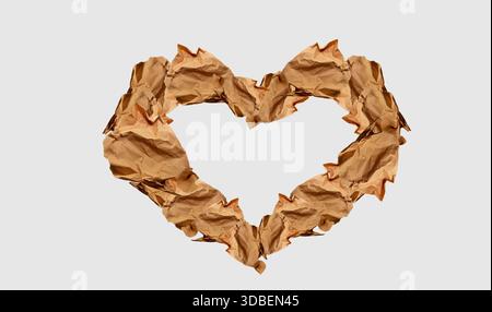 Heart made of paper scraps, isolated. Sustainable Valentine's Day concept, sustainability love. Modern abstract image. Crumpled used paper, sepia tone Stock Photo