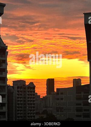 Vertical inspiring view of magical sunset scenery, orange hue sky and cloud skyline in Singapore cityscape. Amazing atmosphere and experience. Stock Photo