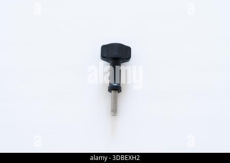 Close-up macro of a single thumb screw with a black head positioned vertically on a clean white background. Ideal for hardware, engineering, product d Stock Photo