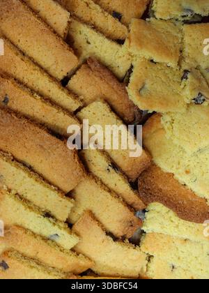 Many sliced cookies with chocolate chips. Golden baked goods with crumbly texture, full frame. Close-up. Copyspace. Stock Photo