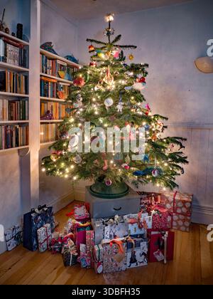 Christmas tree with presents in a family home in London Uk Stock Photo