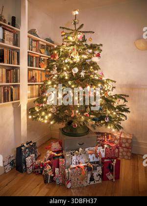 Christmas tree with presents in a family home in London Uk Stock Photo