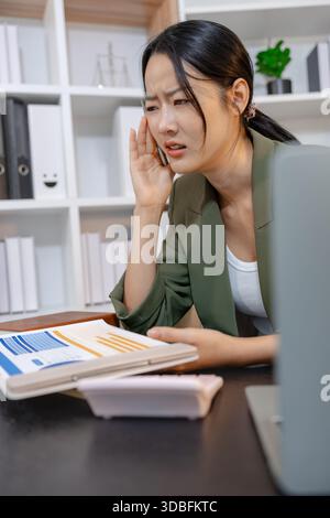 Stressed businesswoman dealing with heavy work pressure, reacting emotionally while reviewing reports and facing tight deadlines, highlighting workpla Stock Photo