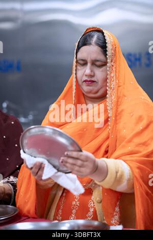 A middle aged Sikh woman volunteering in the langar communal kitchen. In Queens, New York. Stock Photo