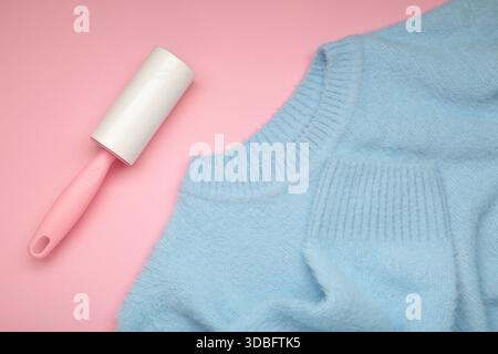 Lint roller on blue texture background to remove pet animal hair. Top view Stock Photo