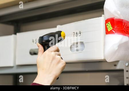 Close-up of employee using scanner on parcel in delivery facility Stock Photo