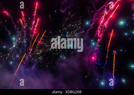 Night Fireworks Show With Bright Spark Trails And Smoke Illumination Against The Dark Sky Stock Photo