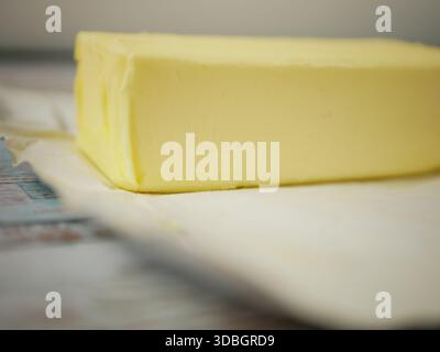 Butter Block in Open Silver Foil Wrapper on Rustic Wooden Surface — Close-Up Fresh Dairy Fat Ingredient for Baking and Cooking Recipes Stock Photo
