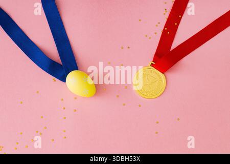 Spring composition with gold medal and decorative floral egg on pastel pink background. Minimal creative Easter egg competition concept. Stock Photo