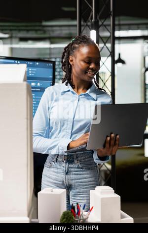 African american developer using modern design software to create a vision for a urban infrastructure, focusing on property construction and residential area planning. Innovation hub. Stock Photo