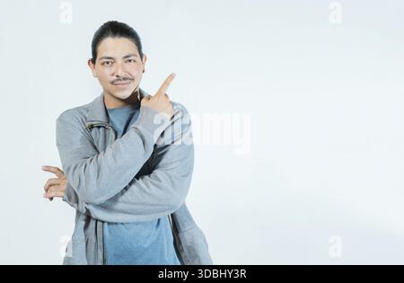 Latin guy pointing an advertising to side isolated. Smiling people pointing a banner on blank space Stock Photo
