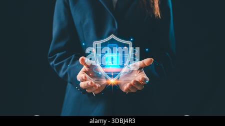 Business professional holding glowing holographic shield with lock icon, symbolizing cybersecurity protection, secure systems, data privacy, digital d Stock Photo