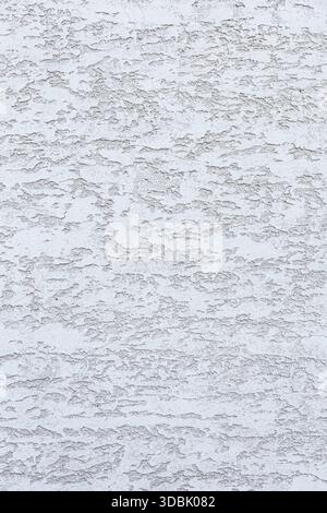 Textured white wall with subtle patterns and variations. The surface appears rough and uneven, creating an interesting visual effect. Stock Photo
