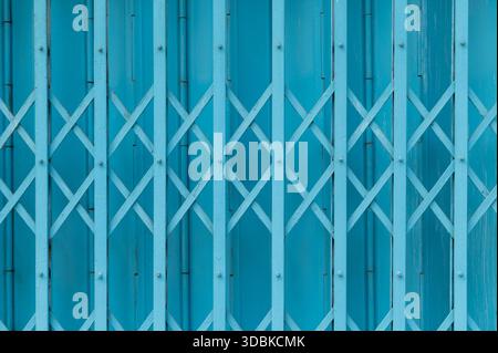 Blue expandable steel gate showing a traditional folding mechanism Stock Photo