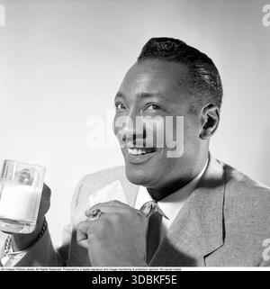 The Delta Rhythm Boys (1952). Snapped here in Sweden on 23 April 1952 – one of the members of the sharp-suited American vocal quartet having a glass of milk. The Delta Rhythm Boys were a groundbreaking US group, formed in 1934 and active until 1987. Famous for their tight harmonies in jazz, R&B and gospel, they starred in over 15 films (more than any other vocal group!), backed Ella Fitzgerald, and wowed Broadway. Hugely popular in Scandinavia from the early 1950s – they recorded Swedish hits like "Flickorna i Småland" and even relocated to Europe in 1956.Photo by Conard (ref: 1997) Stock Photo